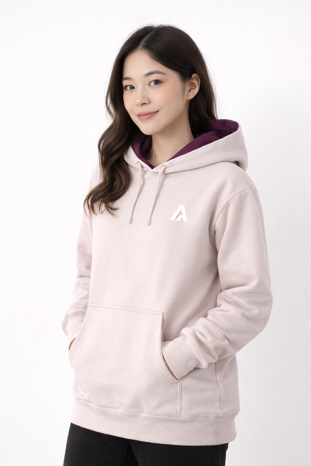 Person wearing a light pink hoodie with a logo on a white background