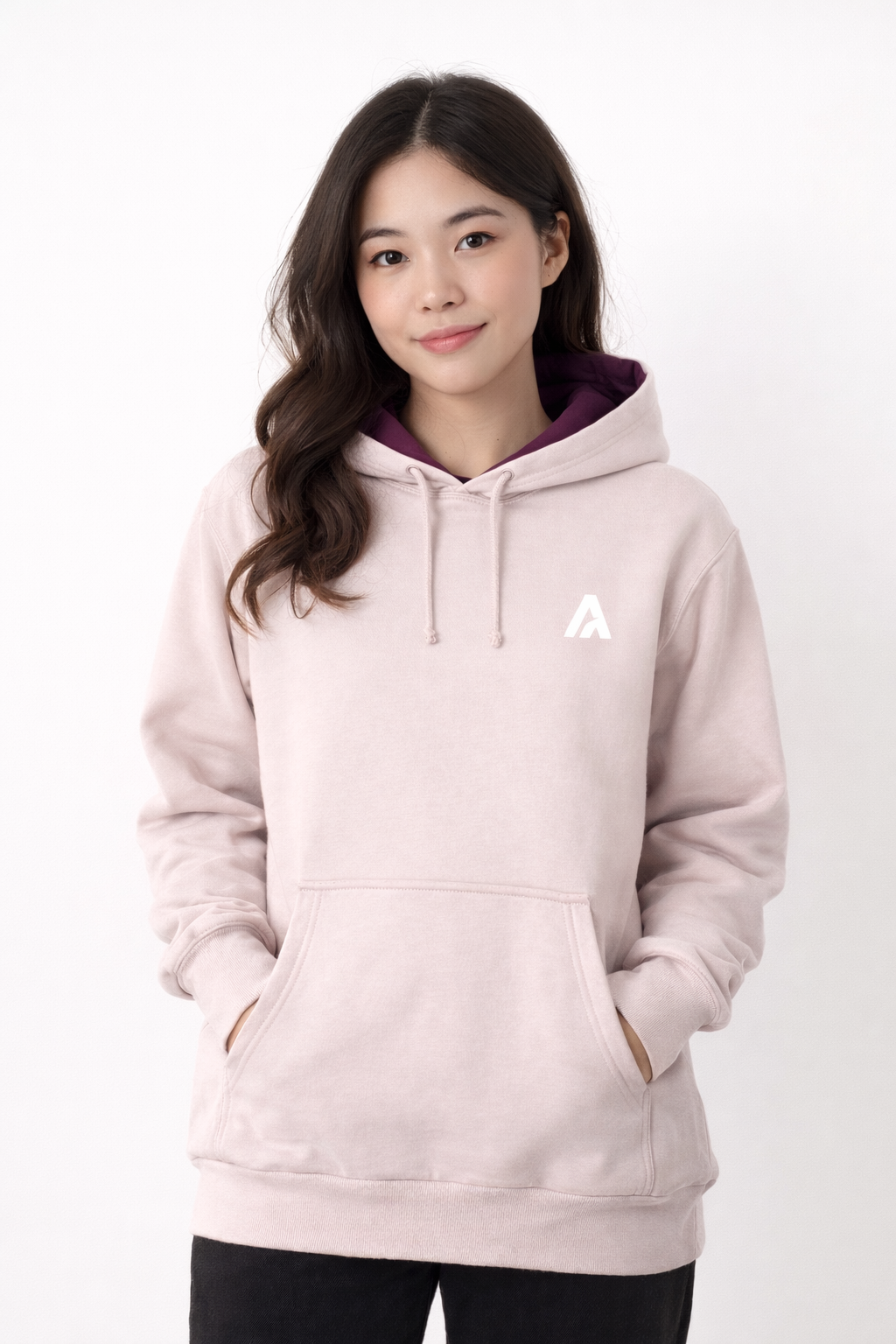 Person wearing a light pink hoodie with a logo on a white background