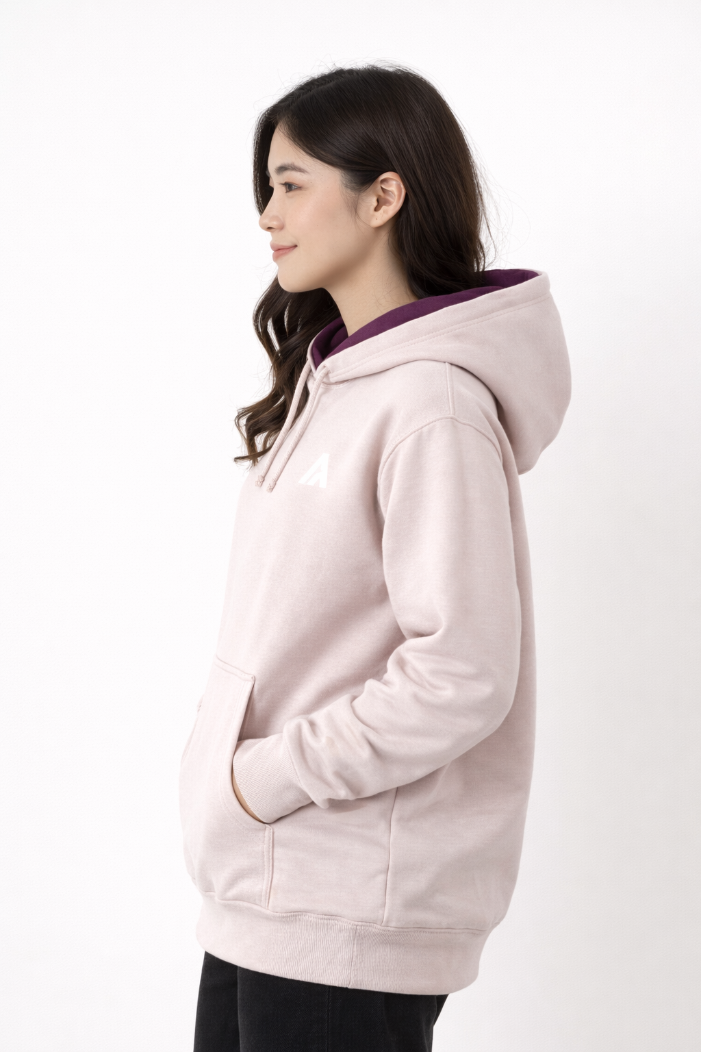 Woman wearing a light pink hoodie with a dark collar on a white background