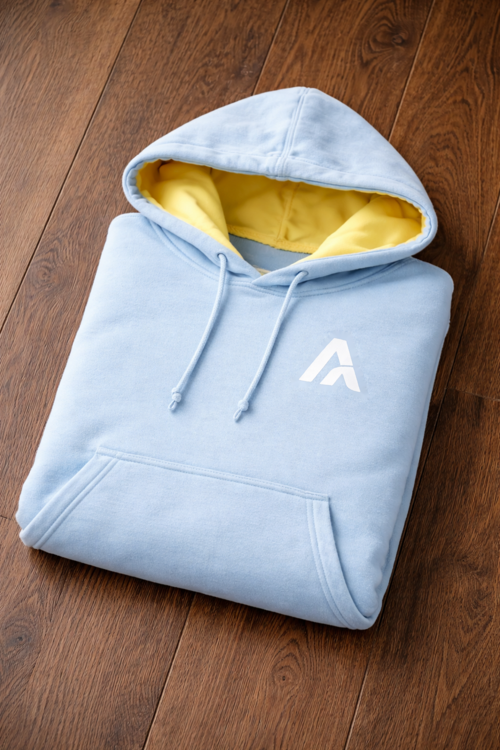 Folded purple hoodie with a logo on a wooden surface