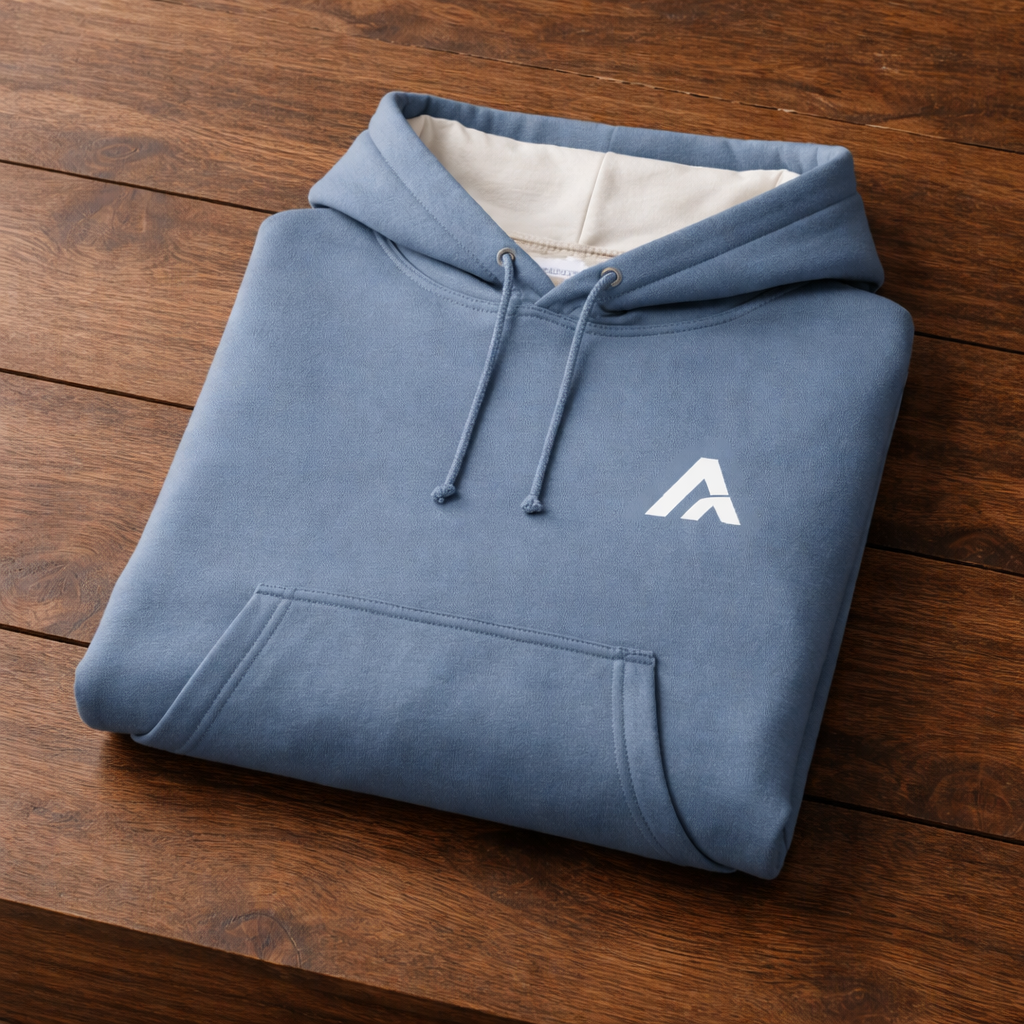 Folded blue hoodie with a white logo on a wooden surface