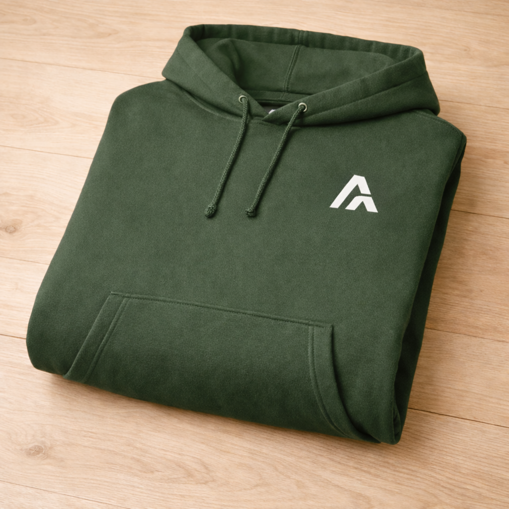 Folded green hoodie with a logo on a wooden surface