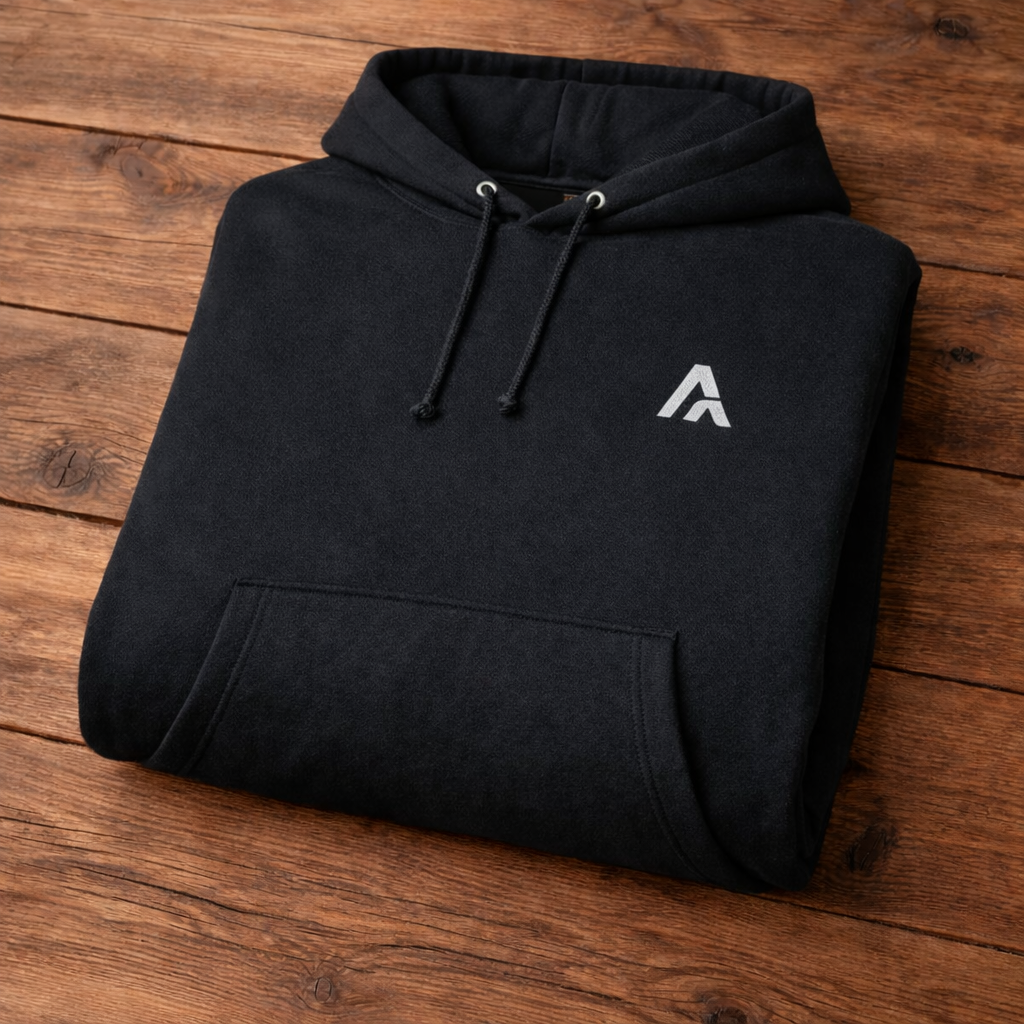 Black hoodie with a white logo on a wooden surface