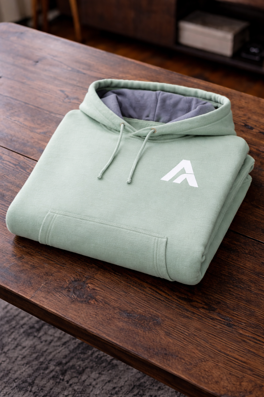 Green hoodie with a logo on a wooden surface