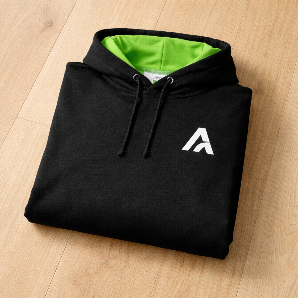 Black Atlas hoodie with neon green hood lining, folded flat on a timber floor, featuring minimalist white Atlas A embroidered logo