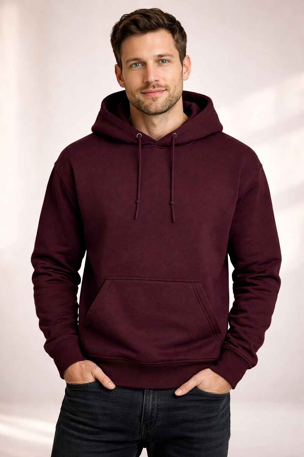 Front view of a man wearing a burgundy pullover hoodie with drawstrings and kangaroo pocket.