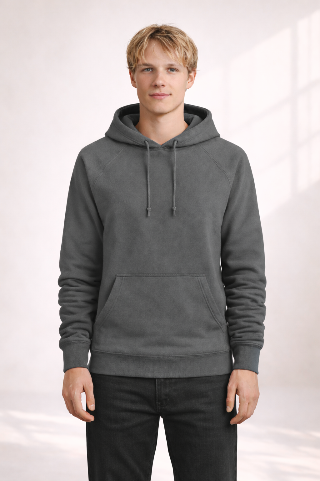 Front view of a man wearing a mens charcoal gray pullover hoodie with drawstrings and kangaroo pocket.