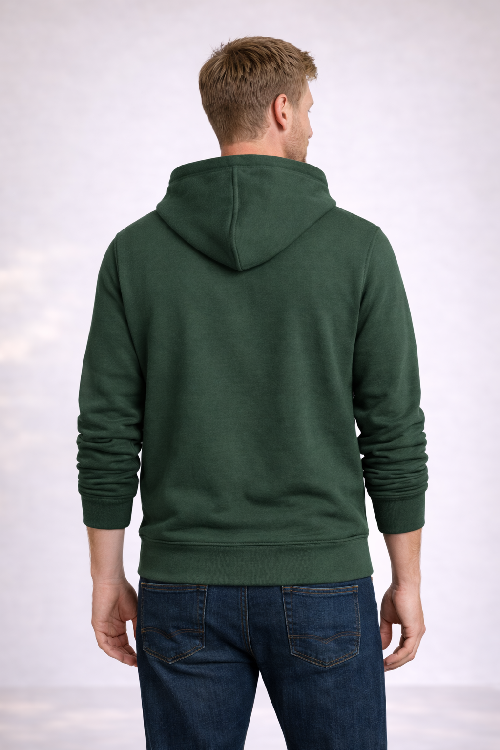 Back view of a man wearing a mens forest green pullover hoodie with hood and ribbed hem.