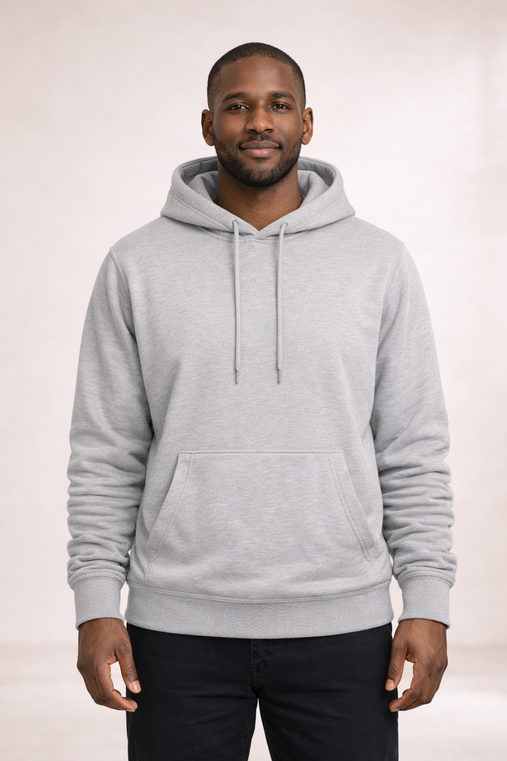 Front view of a man wearing a mens light gray pullover hoodie with drawstrings and kangaroo pocket.